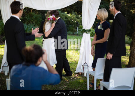 Giovane che abbraccia ogni altro durante il matrimonio in park Foto Stock