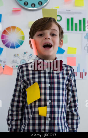 Ritratto di happy businessman di foglietti adesivi sulla faccia in ufficio creativo Foto Stock