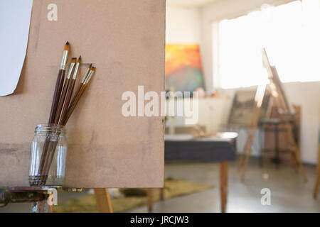 Chiusura del pennello in vaso su cavalletto in classe d'arte Foto Stock