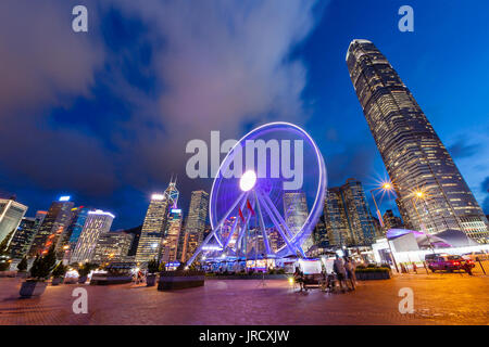 Tramonto su Hong Kong della vibrante vita notturna al molo centrale vicino a Victoria Harbour con l'osservazione ruota in movimento e il centro cittadino di financial district Foto Stock