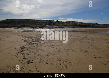 Guardando attraverso la sabbia in spiaggia Ogmore e fino alle case che sono tutti in tutta la collina su un luminoso di mattina presto. Foto Stock