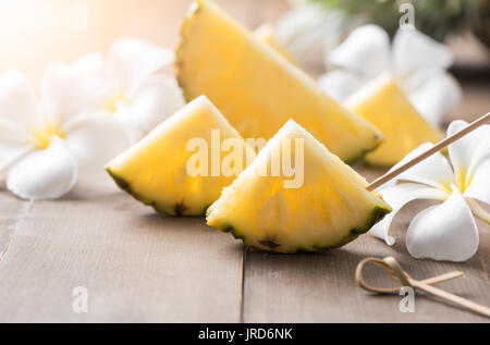 Ananas a fette su uno sfondo di legno popolari, frutta di stagione estiva Foto Stock