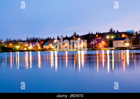 Vista notturna downtown Reyjkjavik oltre il lago Tjornin in Islanda. Foto Stock