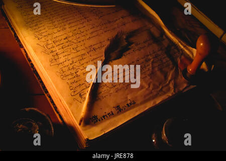 Medieval Book con una penna di piuma e una candela in una fiera medievale. Italia centrale. Foto Stock