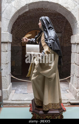 AVILA, Spagna - agosto 2015, 11: all'interno del convento di Santa Teresa, la figura di gesso di santa Teresa di Gesù con un libro e una penna in uno dei cou Foto Stock