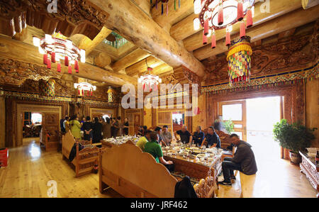 (170805) -- DAOFU, e il Agosto 5, 2017 (Xinhua) -- Foto scattata il 3 agosto, 2017 mostra le persone a una festa di nozze in un albergo dotato di Daofu Tibetan House in Daofu County, a sud-ovest della Cina di provincia di Sichuan. Daofu case tibetane sono comunemente noti come "Bengke'. In tibetano, 'Beng' significa 'integrato e supportato da legno' e 'ke" significa "case". Tibetano Daofu case hanno telai realizzati di registri e un muro costruito con fango o pezzi di pietra. Le loro strutture in legno sono generalmente di colore marrone con red e tetti di bianco. Queste case sono di solito situato ai piedi di una collina e a fianco di un flusso. (Xinhua/Jiang Hongjing Foto Stock