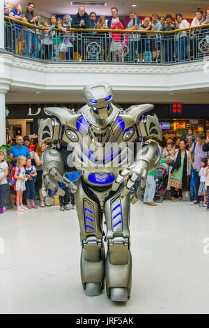 Preston, Lancashire, Regno Unito. Titan il robot, indossando un esoscheletro suit, incanta la folla di St George's Center. Titan è il nome di fase di un parzialmente costume meccanizzato creato da Cyberstein Robots Ltd. Il robot costume è circa 2,4 metri (7,9 piedi) di altezza e 60 kg e aumenta a 350 kg compreso il carrello scorre su e apparecchiatura di bordo. La faccia assomiglia ad un teschio e alcune hanno anche paragonato a un trasformatore. È stato progettato da Nik Fielding, che corre da Cyberstein, Newquay Cornwall, Inghilterra. Foto Stock