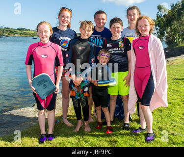 Schull, West Cork, Irlanda. 5 Ago, 2017. Il Sud Ovest dell'Irlanda ha basked nella luce del sole negli ultimi due giorni, con previsioni di pioggia da domani e il resto della settimana, le famiglie stanno prendendo la possibilità di colpire le spiagge. Nella foto a Schull beach dopo un Irish acqua sessione di sicurezza come parte dell'estate nuotata settimana sono: Gli istruttori Moira McCarthy, Ballydehob e Elena Dineen, Barryroe e studenti Emer Caverley, Kilcoe; Ronan O'Donovan, sughero; Eoin Caverley, Dublino; Max Caverly, Dublino; Jamie Caverley, Dublino e Abbie Caverley da Kilcoe. Credito: Andy Gibson/Alamy Live News. Foto Stock