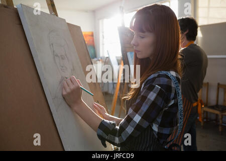 Vista laterale della donna Schizzo su tela in classe d'arte Foto Stock