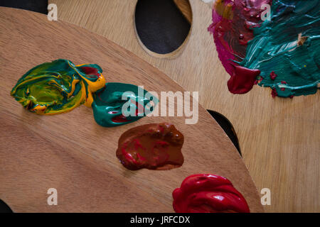 Close up di vernice su legno tavolozza di colori in classe d'arte Foto Stock
