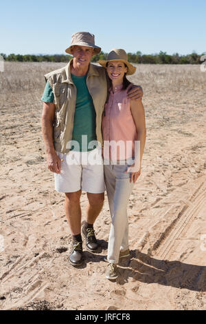 A piena lunghezza ritratto della coppia sorridente in piedi sul paesaggio Foto Stock