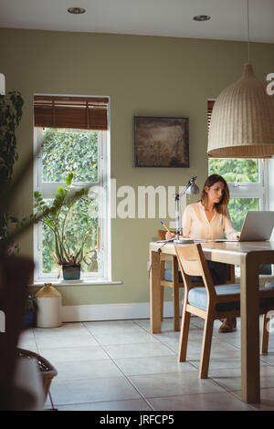 Giovane donna che lavorano nel salotto di casa Foto Stock