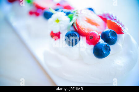 Pavlova con dessert freschi bacche organiche decorato con fiori Foto Stock