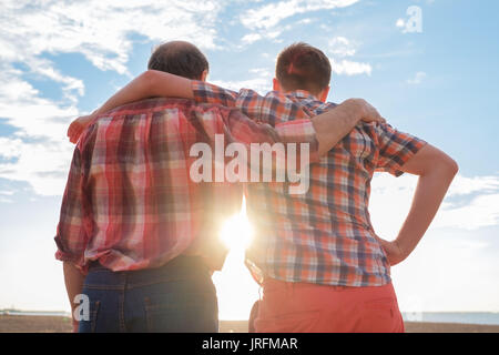 Adulto padre e figlio tenendo le mani al tramonto. Buoni rapporti fra le generazioni Foto Stock