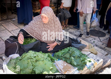 Donna palestinese fa una misera vita vendendo ortaggi freschi nel mercato del quartiere arabo della Città Vecchia di Gerusalemme Foto Stock