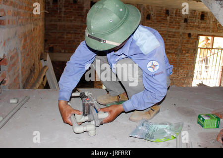 HAI DUONG, Vietnam, 20 Maggio: uomo asiatico installazione di impianti idraulici mediante sigillatura a calore di macchina su maggio, 20, 2014 di Hai Duong, Vietnam. Foto Stock