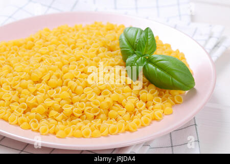 Piatto di pastina gusci su asciugamano a scacchi - close up Foto Stock