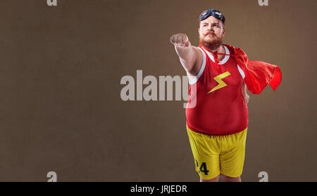 Fat funny man in un costume da supereroe Foto Stock