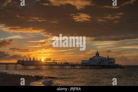 Sunrise over inglese costa sud città di Eastbourne, con il molo e la spiaggia, East Sussex, Inghilterra Foto Stock