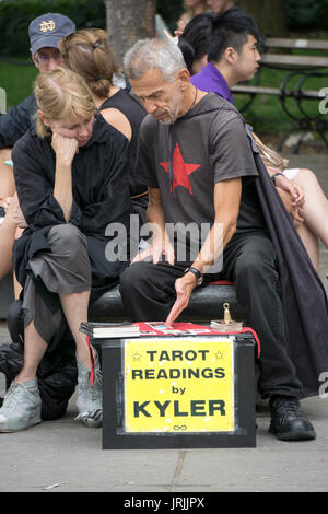 Un tarot card reader facendo una lettura in Washington Square Park nel Greenwich Village di New York City. Foto Stock