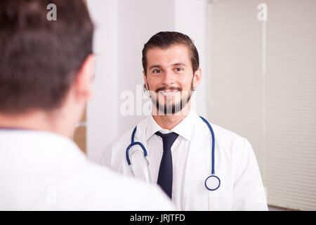 Due medici di fronte eatch altri in ospedale recovery room ta Foto Stock