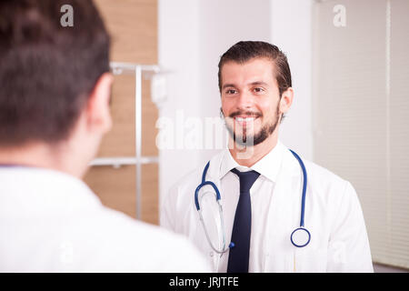 Due medici di fronte eatch altri in ospedale recovery room ta Foto Stock