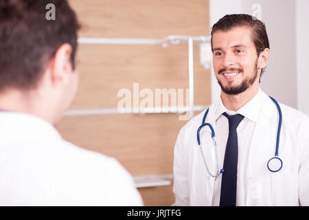 Due medici di fronte eatch altri in ospedale recovery room ta Foto Stock