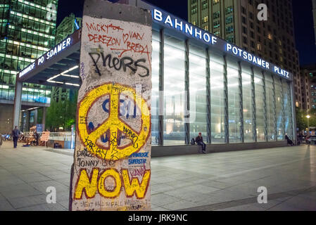 Graffiti del muro di Berlino, vista di una sezione del muro dell'epoca della Guerra fredda che un tempo divise la città in mostra fuori dalla stazione di Potsdamer Platz, Berlino Germania Foto Stock