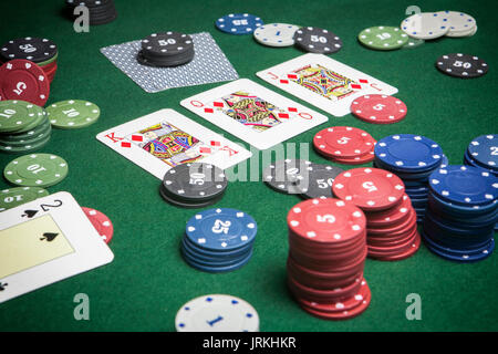 Carte deck poker inglese, poker gioco interessante con una possibile combinazione vincente su sfondo verde Foto Stock