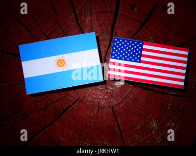 Bandiera argentina con la bandiera degli Stati Uniti su un ceppo di albero isolato Foto Stock