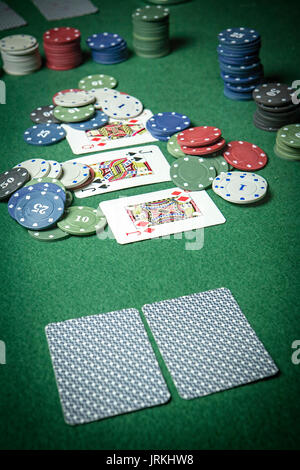 Carte deck poker inglese, Poker chips pila sul tavolo verde Foto Stock