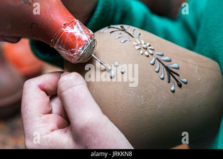 Potter decorare con lo smalto di un pezzo di ceramica prima della messa in stufa con rami di disegni, argilla ceramica ceramica tipica di Bailén, Jaen provi Foto Stock