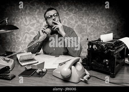 Segretario di fumare una sigaretta mentre si parla al telefono, 1960's scena Foto Stock