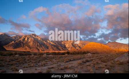Riflessi aranciati coprire le montagne e le nuvole tramonto Alabama Hills Foto Stock