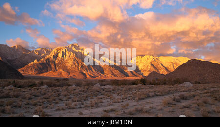 Riflessi aranciati coprire le montagne e le nuvole tramonto Alabama Hills Foto Stock