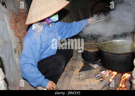 Donna asiatica di ebollizione torta di riso Foto Stock