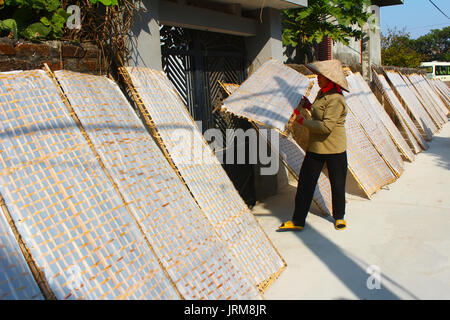 HAI DUONG, Vietnam, 17 gennaio: agricoltore tradizionalmente realizzati in carta di riso in essiccazione sun a gennaio, 17, 2015 di Hai Duong, Vietnam Foto Stock