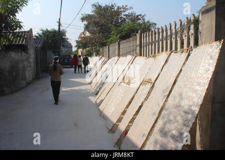 HAI DUONG, Vietnam, 17 gennaio: agricoltore tradizionalmente realizzati in carta di riso in essiccazione sun a gennaio, 17, 2015 di Hai Duong, Vietnam Foto Stock