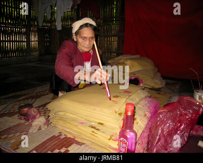 HAI DUONG, Vietnam, Settembre, 20: vecchia donna scrittura su carta con la penna del cappello nella sua casa il settembre, 20, 2013 di Hai Duong, Vietnam Foto Stock