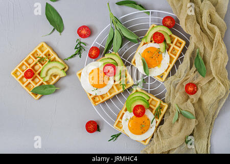 Una sana prima colazione - cialde, uova, avocado, i pomodori e le erbe. Lay piatto. Vista superiore Foto Stock