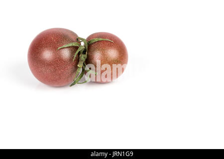 Letti piccoli rossi pomodori nero su sfondo bianco Foto Stock