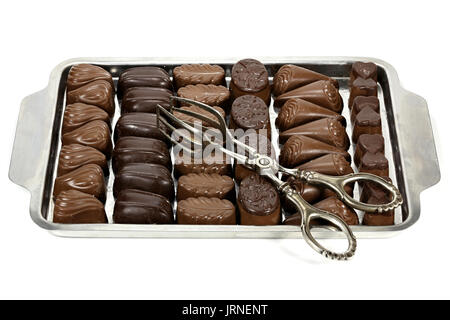 Vassoio con belga praline di cioccolato e pasticceria tong isolati su sfondo bianco Foto Stock