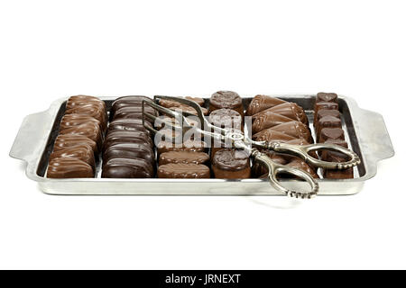 Vassoio con belga praline di cioccolato e pasticceria tong isolati su sfondo bianco Foto Stock