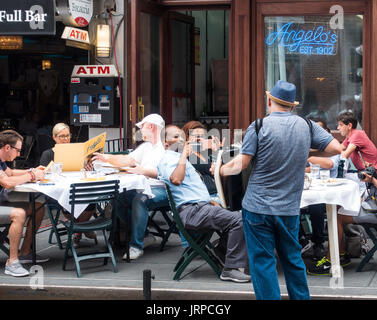 Un suonatore di fisarmonica che suona musica tradizionale italiana per clienti esterni Ristorante Angelo su Mulberry Street in Little Italy a New Città di York Foto Stock