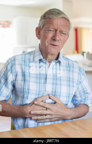 Uomo maturo che soffrono di dolore allo stomaco a casa Foto Stock