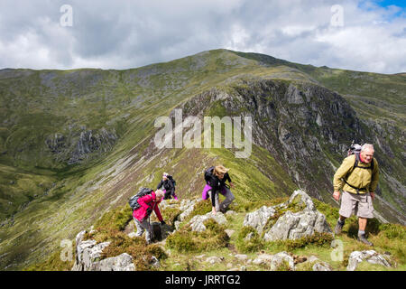 Gli escursionisti escursionismo fino Pen yr Helgi Du con Carnedd Llewelyn dietro in Carneddau montagne del Parco Nazionale di Snowdonia. Ogwen, Conwy, Galles del Nord, Regno Unito Foto Stock