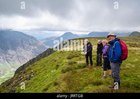 Gli escursionisti escursionismo su Carnedd Filiast y al di sopra di Nant Ffrancon valle nelle montagne del Parco Nazionale di Snowdonia. Bethesda, Gwynedd, Galles del Nord, Regno Unito Foto Stock
