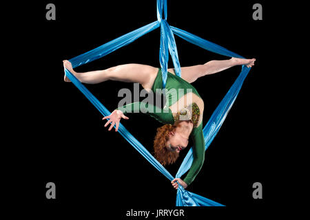 Trapezista donna facendo alcuni trucchi su tessuti di seta Foto Stock