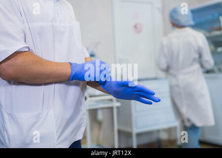 Medico indossando guanti di lattice. medicina e concetto di salute. in ospedale. Foto Stock