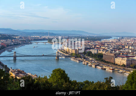 Vista dalla collina Gellert oltre il Danubio verso Pest e il palazzo del Parlamento con la catena ponte che attraversa il fiume, Budapest, Ungheria Foto Stock